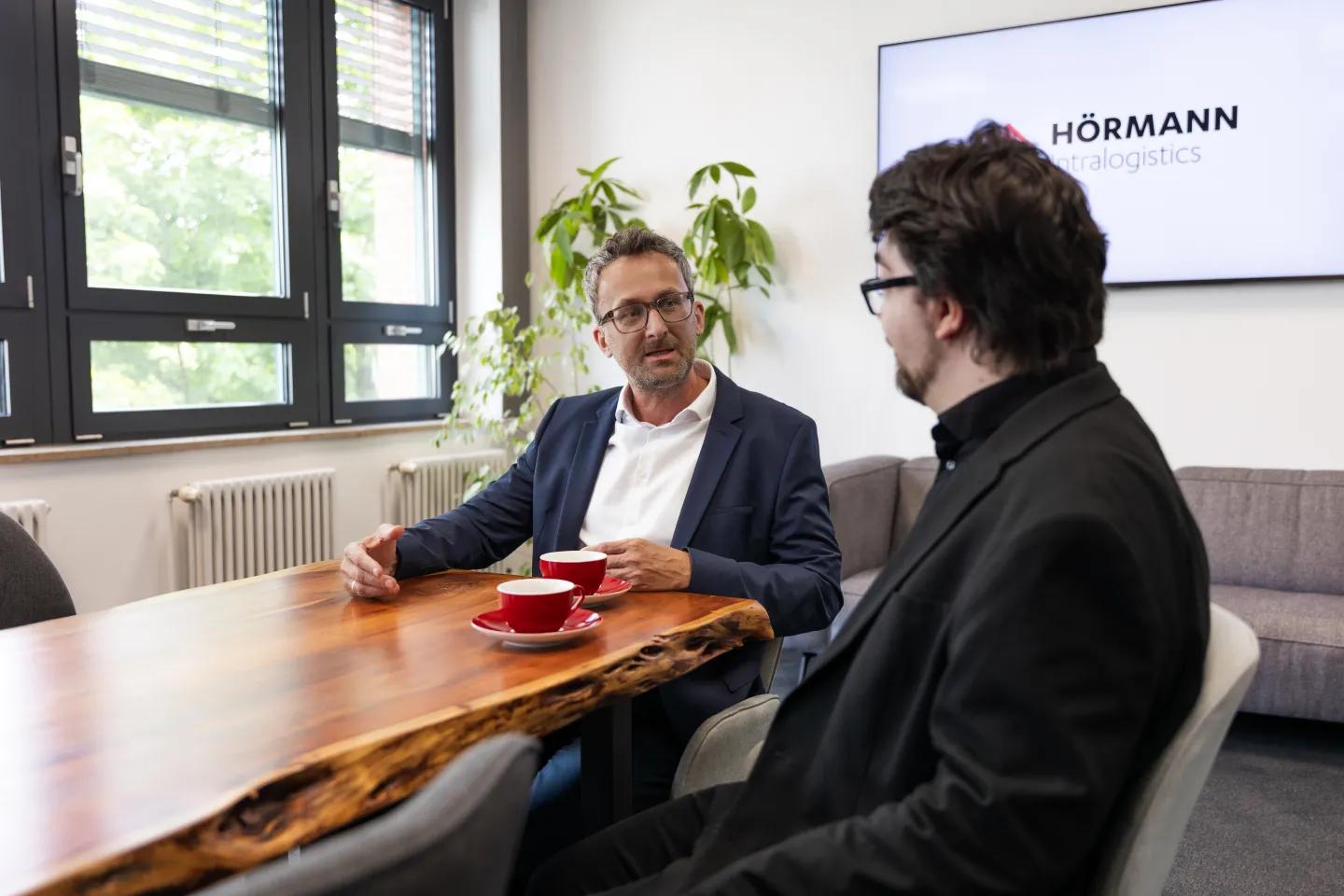 Rainer Baumgartner (l., Hörmann Intralogistics) im Gespräch mit Marvin Meyke (r., materialfluss).