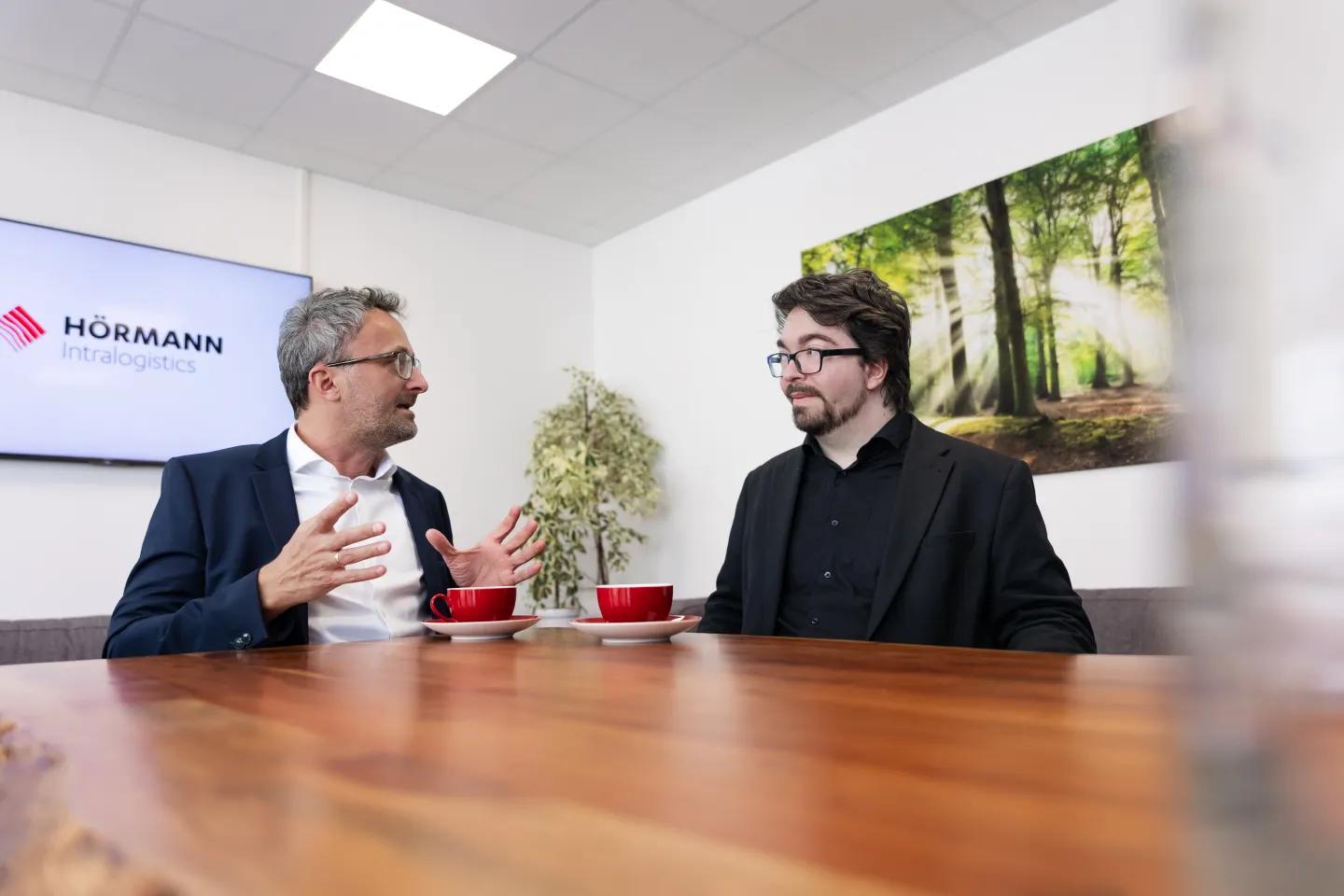 Rainer Baumgartner (l., Hörmann Intralogistics) im Gespräch mit Marvin Meyke (r., materialfluss).